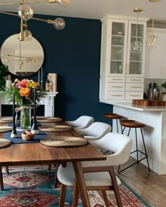 the dining room table is set with white chairs