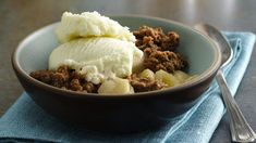 a bowl filled with food sitting on top of a blue cloth next to a fork