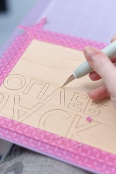 someone is cutting out the words on a piece of wood with a sharpie pen