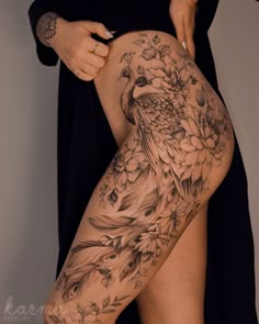 a woman is showing off her thigh with flowers and birds tattoo on it's side