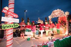 some people are dressed up and standing in front of the street signs at christmas time