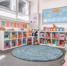 a child's playroom with bookshelves, rug and stuffed animals on the floor