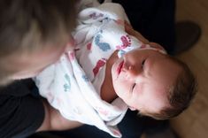 a woman holding a baby wrapped in a blanket