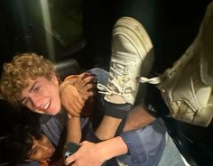 two people sitting in the back seat of a car with their feet on each other