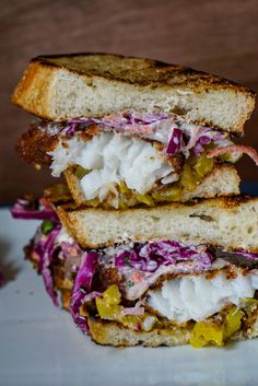 a sandwich cut in half on a plate with coleslaw and mayonnaise