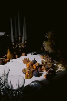 the table is covered with fruit and candles