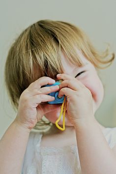 a young child holding a toy in front of his face