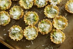 small appetizers with cheese and broccoli are on a baking sheet, ready to be eaten