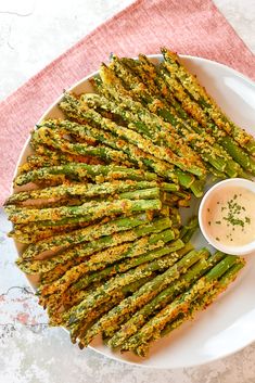 cooked asparagus on a plate with dipping sauce