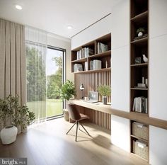 a room with a desk, bookshelf and large window overlooking the trees outside