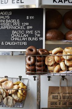 several baskets of doughnuts are on display in front of a sign for the bakery