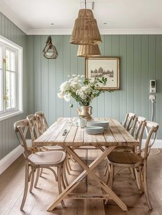 a dining room with green walls and wooden furniture