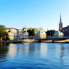 the water is calm and blue with buildings in the background