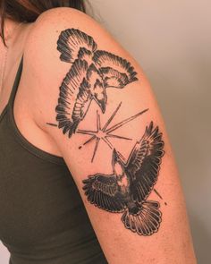 a woman with a tattoo on her arm has two birds flying over the sun and stars