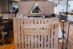 the inside of a restaurant with lots of wooden furniture and signs on the walls that read lindsay lewis