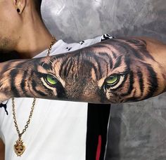 a man's arm with a tiger face and green eyes on the upper half of his arm