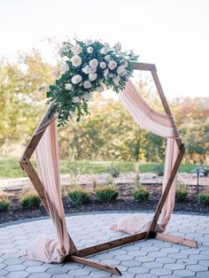 a wedding arch decorated with white flowers and greenery