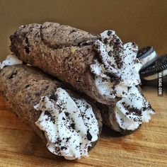 two chocolate crepes with white frosting on top and oreo cookies in the background