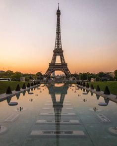 the eiffel tower in paris, france at sunset with its reflection on the water