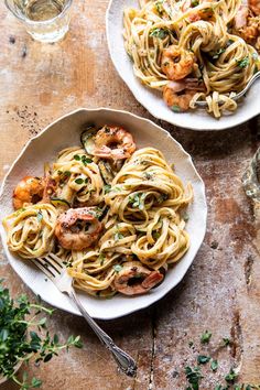 two plates of pasta with shrimp and scallops