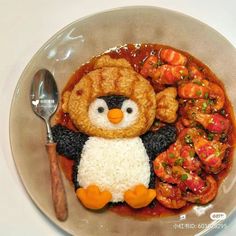 a plate topped with rice and meat covered in a penguin