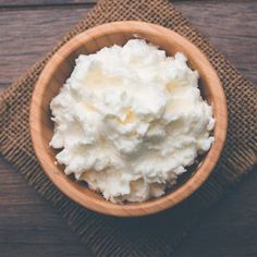 a bowl filled with whipped cream sitting on top of a wooden table next to a napkin