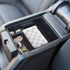 an organized compartment in the back seat of a car with keys, lighters and other items