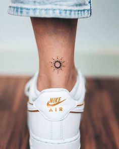 a woman's foot with a tattoo on her left ankle and the word air written in gold ink