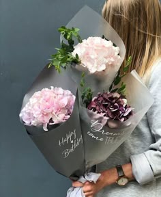 a woman holding flowers in her hands with the words happy birthday written on it