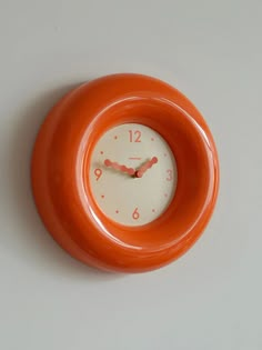 an orange and white clock on the wall