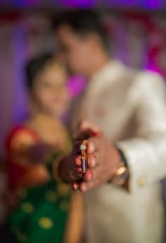 the bride and groom are holding their wedding ring