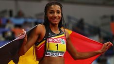 a female athlete holding a flag and posing for the camera