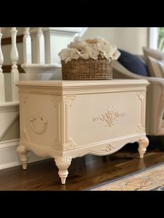 a white chest sitting on top of a hard wood floor next to a stair case