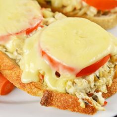 two sandwiches with cheese and tomatoes on them