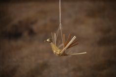 a bird made out of sticks hanging from a string