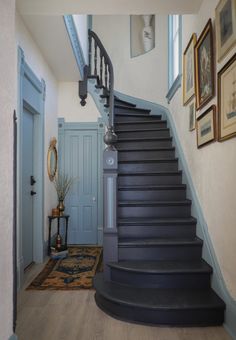 there is a staircase leading up to the second floor in this house with pictures on the wall