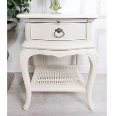 a white table with drawers and flowers on top