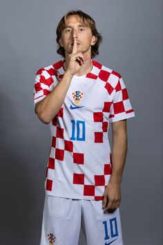 a soccer player poses for a photo in croatia's national team shirt and shorts