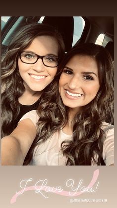 two young women taking a selfie in the back seat of a car with their arms around each other