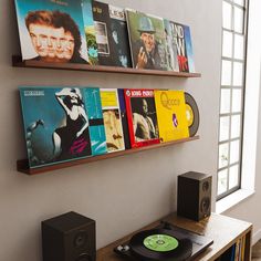 a record player sitting on top of a wooden table next to a wall mounted cd player