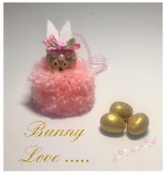 there is a bunny in a pink dress next to some gold eggs