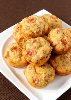 a white plate filled with muffins sitting on top of a brown tablecloth