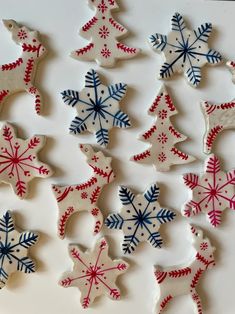 decorated cookies are arranged on a white surface