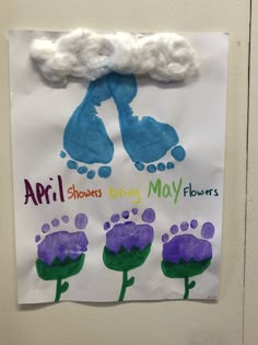 a child's hand and foot print on a white paper with purple flowers in the middle