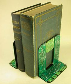 an open book sitting on top of a green computer circuit board next to another book