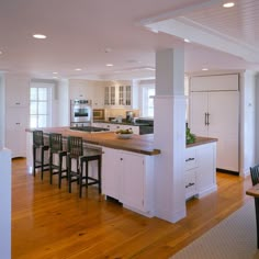 an image of a kitchen with white cabinets and wood flooring in the middle of it