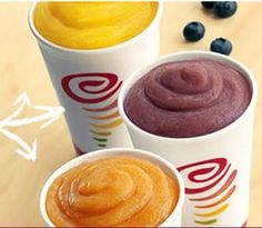 three cups filled with different types of food on top of a wooden table next to blueberries