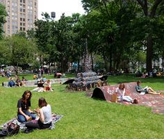 people sitting on the grass in a park