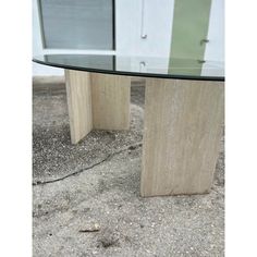 a glass and wood table sitting on the ground