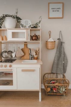 a kitchen with white cupboards and shelves filled with pots, pans and utensils